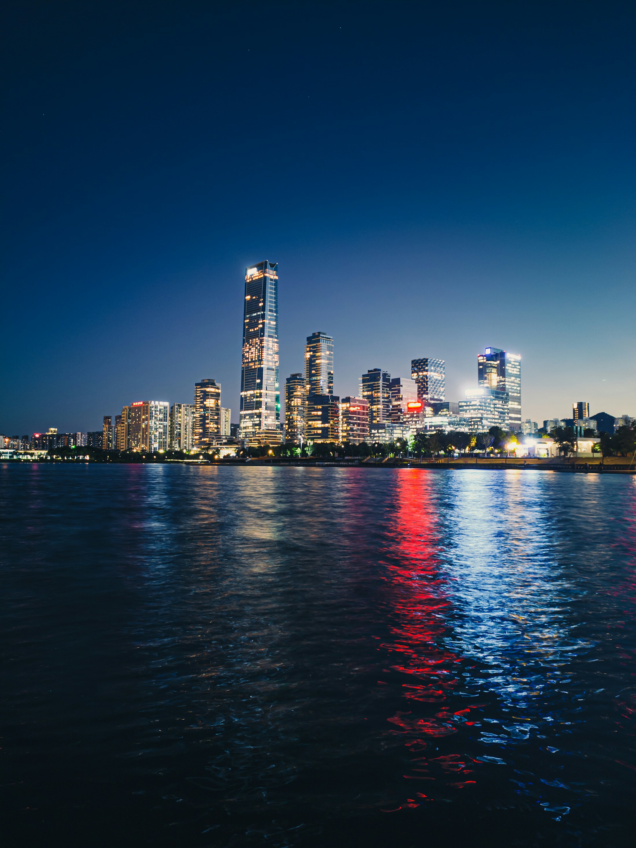 Shenzhen lights reflected across the water after dark